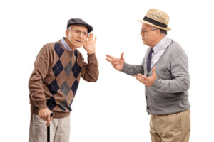 A man with hearing loss leans in to hear what his friend is saying, one of the strategies for better communication with hearing loss.